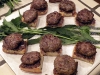 Lamb sliders over kalamata olive and roasted garlic spread on plank