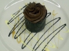 3 layered chocolate mousse cake with chocolate, vanilla cream and caramel sauces