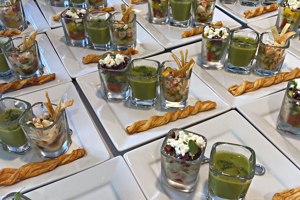 Chilled soup shots and canapés lined up for a party